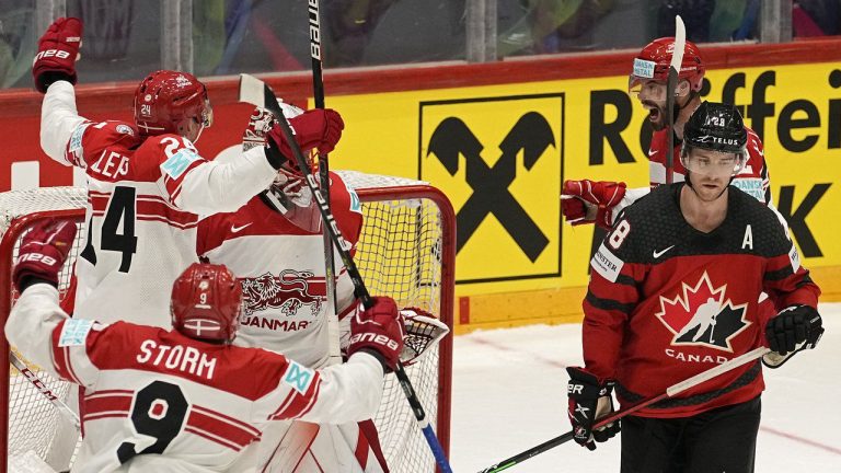 Denmark's players celebrate beside Canada's Damon Severson, right, after winning the group A Hockey World Championship match between Canada and Denmark in Helsinki, Finland, Monday May 23 2022. (Martin Meissner/CP/AP)
