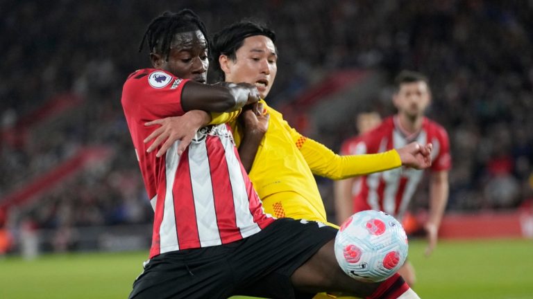 Southampton's Mohammed Salisu, left, challenges for the ball with Liverpool's Takumi Minamino during their English Premier League soccer match in Southampton, England, Tuesday, May 17, 2022. (Frank Augstein/AP)