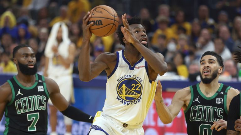 Golden State Warriors forward Andrew Wiggins (22) shoots against Boston Celtics guard Jaylen Brown (7) and forward Jayson Tatum (0) during the first half of Game 5 of basketball's NBA Finals in San Francisco, Monday, June 13, 2022. (Jed Jacobsohn/AP)