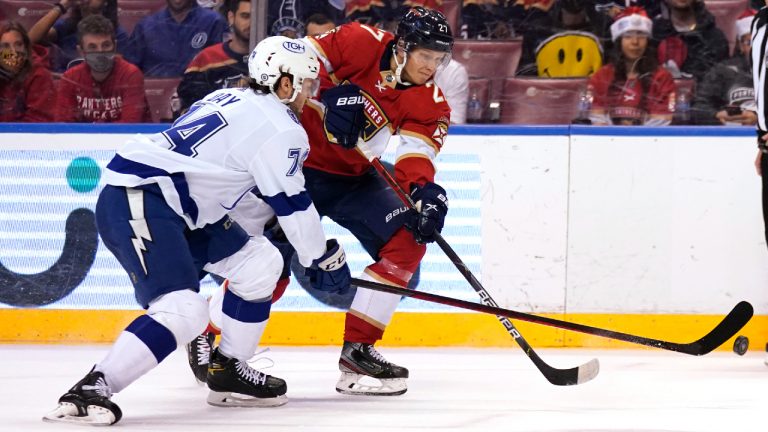 Florida Panthers center Eetu Luostarinen, right, passes the puck as Tampa Bay Lightning defenseman Sean Day (74) defends during the second period of an NHL hockey game, Thursday, Dec. 30, 2021, in Sunrise, Fla. (Lynne Sladky/AP)