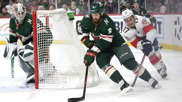 Minnesota Wild defenseman Jordie Benn (8) controls the puck in front of Florida Panthers left wing Mason Marchment (17) while Wild goaltender Cam Talbot watches during the second period of an NHL hockey game. (Andy Clayton-King/AP)