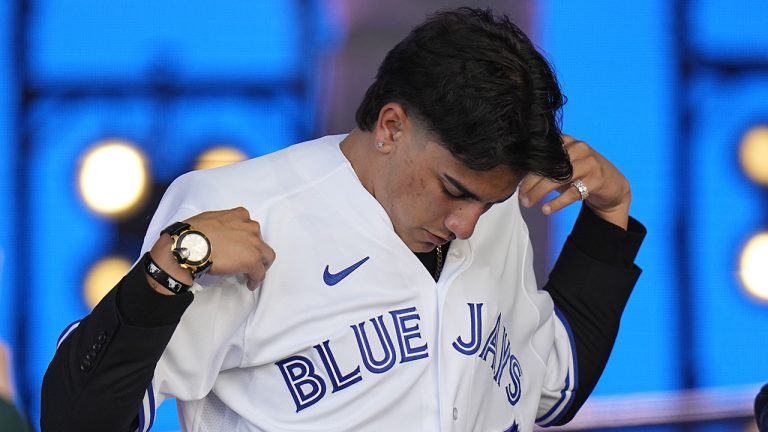Brandon Barriera puts on a jersey after being selected by the Toronto Blue Jays with the 23rd pick of the 2022 MLB baseball draft, Sunday, July 17, 2022, in Los Angeles. (Jae C. Hong/AP)