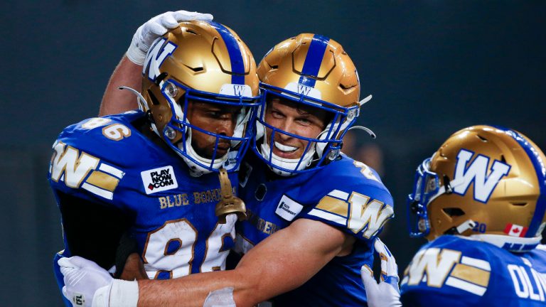 Winnipeg Blue Bombers' Carlton Agudosi (86) and Greg Ellingson (2) celebrate Agudosi’s game winning touchdown against the Calgary Stampeders during the second half of CFL action in Winnipeg, Friday, July 15, 2022. (John Woods/CP)