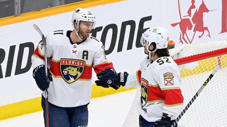 Florida Panthers left wing Jonathan Huberdeau (11) is congratulated by defenseman MacKenzie Weegar (52) after Huberdeau scored an empty-net goal against the Nashville Predators during the third period of an NHL hockey game Saturday, April 9, 2022, in Nashville, Tenn. The Panthers won 4-1. (Mark Zaleski/AP Photo)