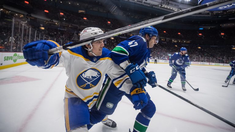 Buffalo Sabres' Peyton Krebs, left, and Vancouver Canucks' Noah Juulsen vie for position during the second period of an NHL hockey game in Vancouver, B.C., Sunday, March 20, 2022. Darryl Dyck/CP)