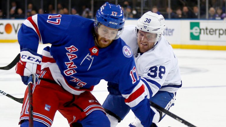 New York Rangers' Kevin Rooney (17) skates with the puck past Toronto Maple Leafs' Rasmus Sandin (38) during the second period of an NHL hockey game Wednesday, Jan. 19, 2022, in New York. (John Munson/AP)