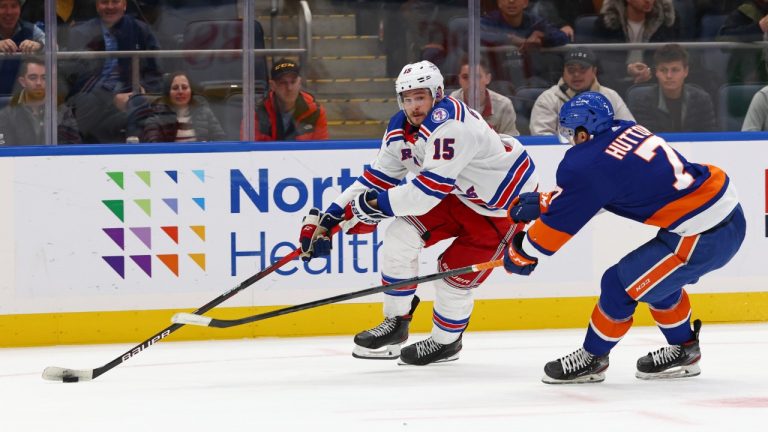 New York Rangers right wing Julien Gauthier (15) looks to pass the puck as New York Islanders defenseman Grant Hutton (7) defends during the first period of an NHL hockey game, Wednesday, Nov. 24, 2021, in Elmont, N.Y. (Rich Schultz/AP)