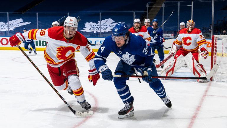 Auston Matthews #34 of the Toronto Maple Leafs battles against Matthew Tkachuk #19 of the Calgary Flames during the third period at the Scotiabank Arena on February 22, 2021 in Toronto, Ontario, Canada. (Photo by Mark Blinch/NHLI via Getty Images)