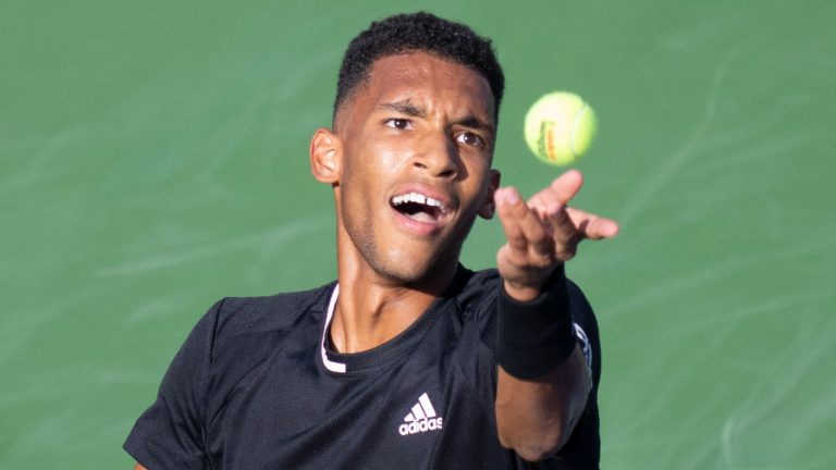 Canada’s Felix Auger-Aliassime tosses the ball to serve to Cameron Norrie of Great Britain during round of sixteen play at the National Bank Open tennis tournament, Thursday, August 11, 2022 in Montreal. (Paul Chiasson/CP)