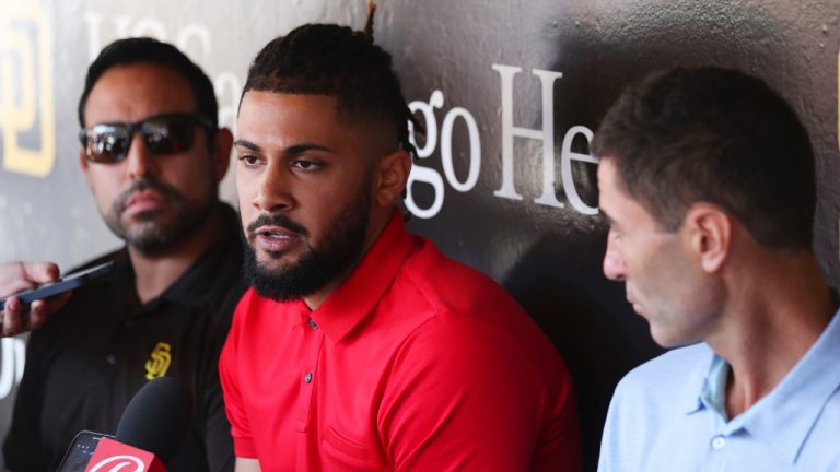 San Diego Padres' Fernando Tatis Jr., center, speaks to the media about his 80 game suspension from baseball after testing positive for Clostebol, a performance-enhancing substance in violation of Major League Baseball's Joint Drug Prevention and Treatment Program, Tuesday, Aug. 23, 2022, in San Diego. (Derrick Tuskan/AP)