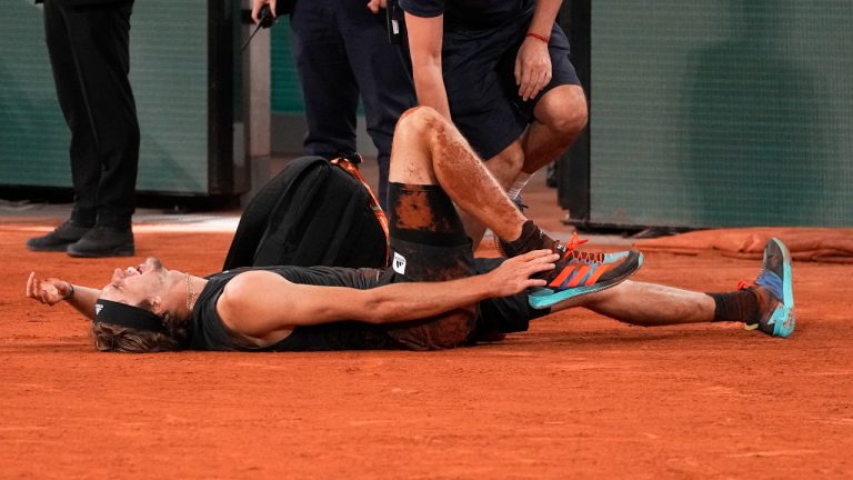 Germany's Alexander Zverev grimaces in pain and shows his ankle after falling as he plays Spain's Rafael Nadal, during their semifinal match of the French Open tennis tournament at the Roland Garros stadium Friday, June 3, 2022 in Paris. Alexander Zverev stopped playing because of an injury. (Michel Euler/AP)