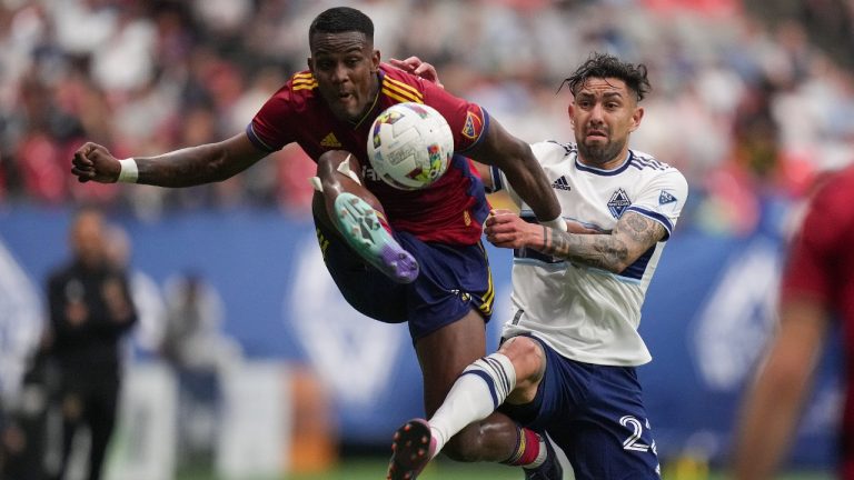Real Salt Lake's Sergio Cordova, left, and Vancouver Whitecaps' Erik Godoy vie for the ball during the first half of an MLS soccer game in Vancouver, on Saturday, June 4, 2022. (Darryl Dyck/CP)