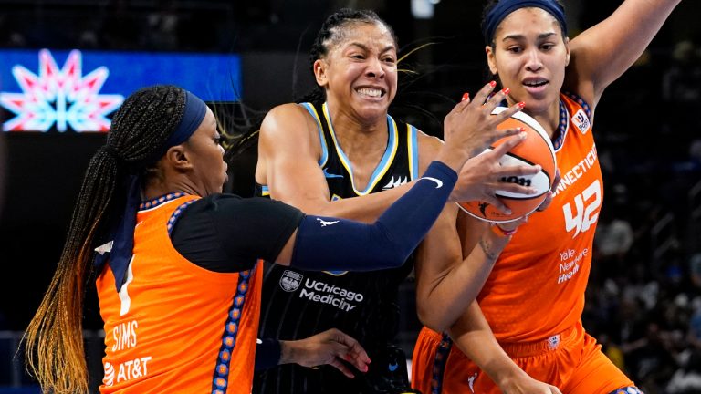 Chicago Sky forward Candace Parker, center, drives to the basket against Connecticut Sun guard Odyssey Sims, left, and center Brionna Jones during the second half of Game 2 in a WNBA basketball playoffs semifinal Wednesday, Aug. 31, 2022, in Chicago. The Sky won 85-77. (Nam Y. Huh/AP)