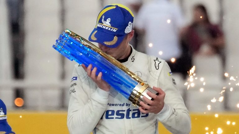 World Champion Mercedes-EQ Formula E Team's driver Stoffel Vandoorne of Belgium kisses the winner's trophy after winning the season 8 of the ABB FIA Formula E World Championship in Seoul, South Korea, Sunday, Aug. 14, 2022. (Lee Jin-man/AP)