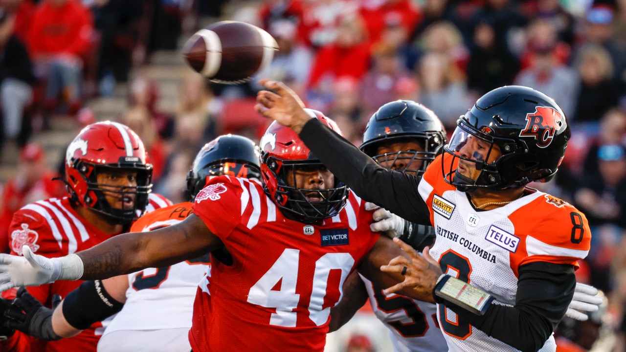 BC Lions quarterback Vernon Adams, right, throws the ball as Calgary Stampeders defensive lineman Shawn Lemon closes in during second half CFL football action in Calgary, Saturday, Sept. 17, 2022. (Jeff McIntosh/THE CANADIAN PRESS)