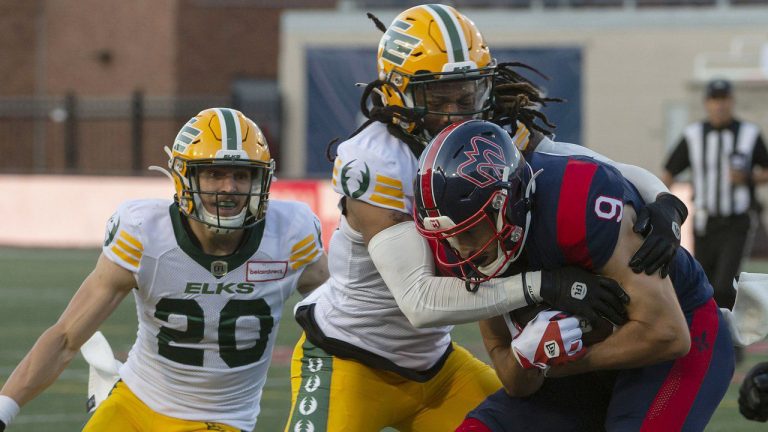 Edmonton Elks' Treston Decoud tackles Montreal Alouettes' Jake Wieneke during first half CFL action in Montreal on Thursday, July 14, 2022. (Peter McCabe/CP)