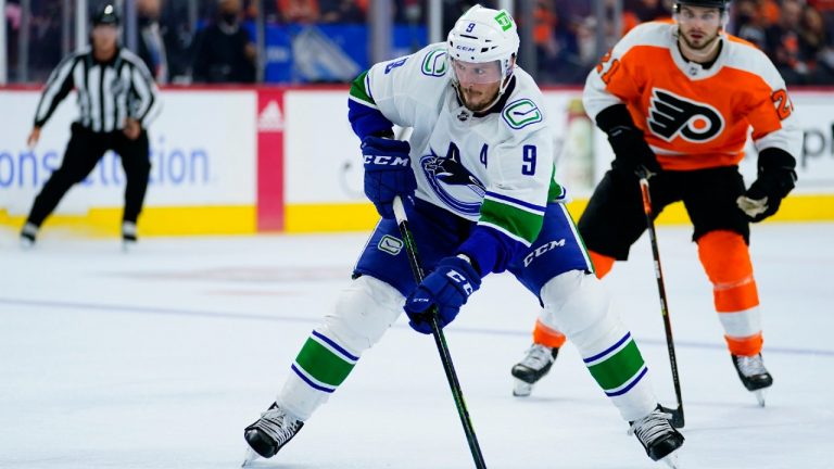 Vancouver Canucks' J.T. Miller, center, skates past Philadelphia Flyers' Scott Laughton during the first period of an NHL hockey game, Friday, Oct. 15, 2021, in Philadelphia. (Matt Slocum/AP)