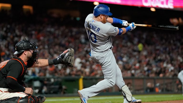 Los Angeles Dodgers designated hitter Justin Turner, right, hits an RBI single in front of San Francisco Giants catcher Joey Bart during the fourth inning of a baseball game in San Francisco, Saturday, Sept. 17, 2022. (Jeff Chiu/AP)