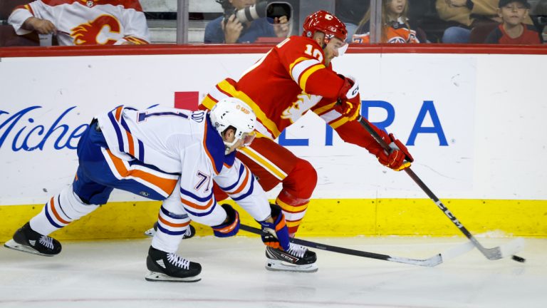 Edmonton Oilers forward Ryan Mcleod, left, checks Calgary Flames forward Jonathan Huberdeau during second period NHL pre-season hockey action in Calgary. (Jeff McIntosh/CP)