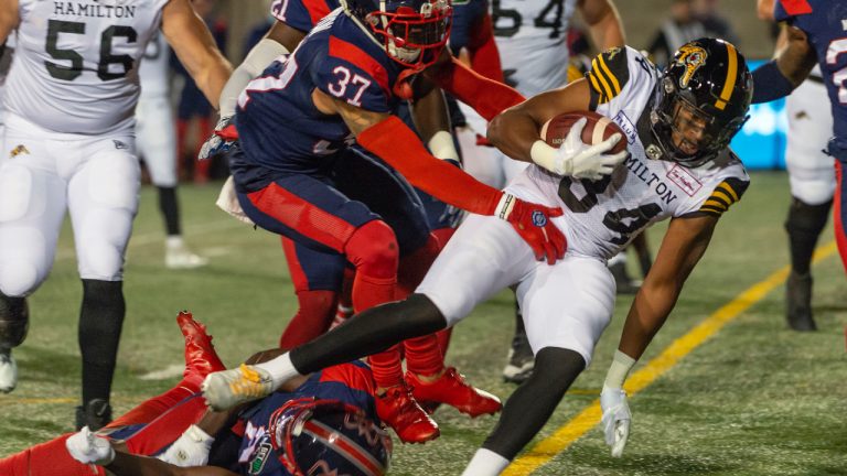 Hamilton Tiger-Cats' Wes Hills rushes into the end zone for a touchdown as Montreal Alouettes' Wesley Sutton (37) defends during first half CFL football action in Montreal on Friday, Sept. 23, 2022. (Peter McCabe/CP)