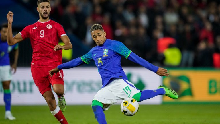 Brazil's Raphinha, right, kicks the ball next to Tunisia's Mortadha Ben Ouanes during the international friendly soccer match between Brazil and Tunisia at the Parc des Princes stadium in Paris, France, Tuesday, Sept. 27, 2022. (Christophe Ena/AP)