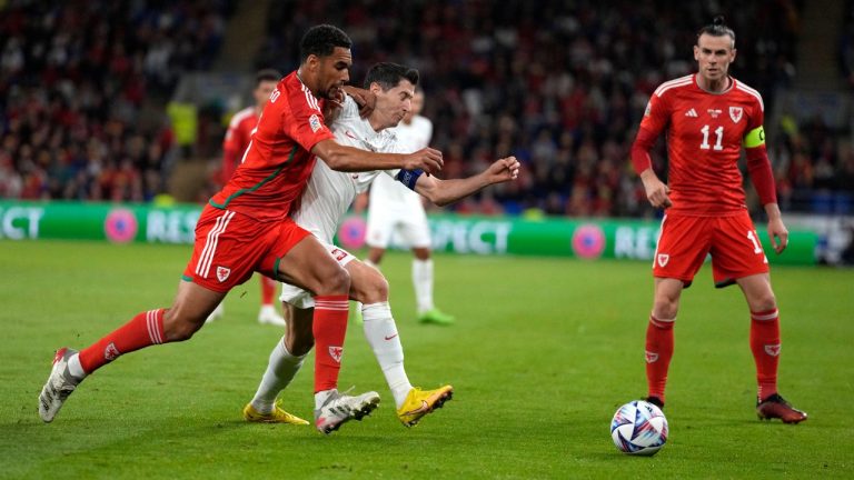 Wales' Ben Davies, left, challenges for the ball with Poland's Robert Lewandowski during the UEFA Nations League soccer match between Wales and Poland at the Cardiff City Stadium in Cardiff, Wales, Sunday, Sept. 25, 2022. (Frank Augstein/AP)