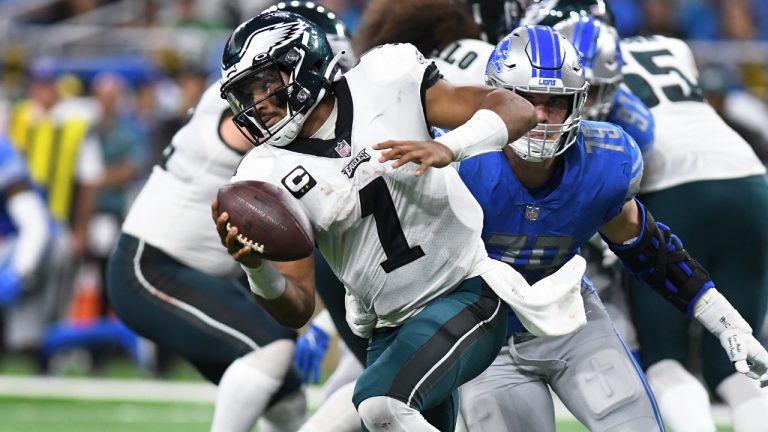Philadelphia Eagles quarterback Jalen Hurts (1) escapes Detroit Lions defensive end Aidan Hutchinson (97) in the first half of an NFL football game in Detroit, Sunday, Sept. 11, 2022. (Lon Horwedel/AP)