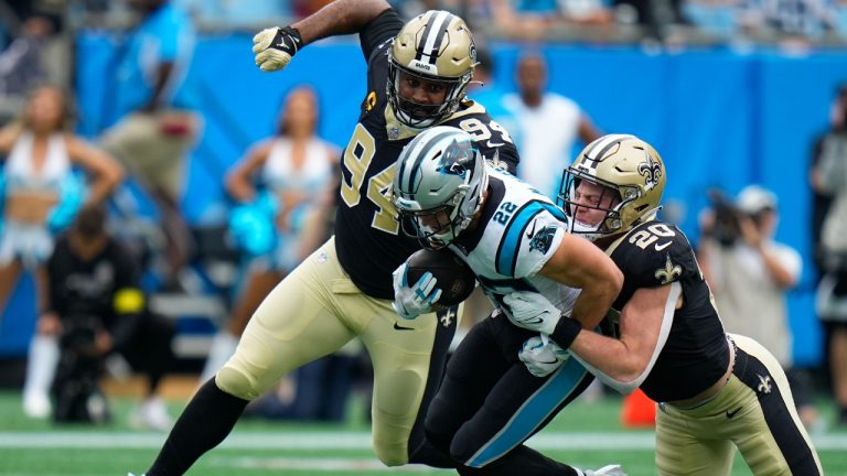 Carolina Panthers running back Christian McCaffrey (22) carries the ball against New Orleans Saints linebacker Pete Werner (20) and defensive end Cameron Jordan (94) during the first half of an NFL football game, Sunday, Sept. 25, 2022, in Charlotte, N.C. (Rusty Jones/AP)
