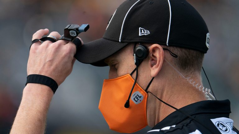 A CFL referee wears an orange face mask during the marking of National Truth and Reconciliation day in 2021. (Peter Power/CP)