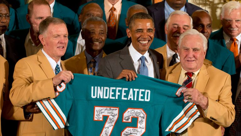 Miami Dolphins football quarterback Bob Griese, left, President Barack Obama and 1972 Dolphins Coach Don Shula, right, hold a signed jersey in the East Room of the White House in Washington during a ceremony honoring the Super Bowl VII football Champion Miami Dolphins. (Jacquelyn Martin/AP)