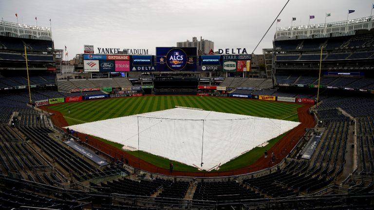 The rain tarp covers the field as a light rain falls on Yankee Stadium before Game 4 of an American League Championship baseball series between the New York Yankees and the Houston Astros, Sunday, Oct. 23, 2022, in New York. (AP Photo/Julia Nikhinson)