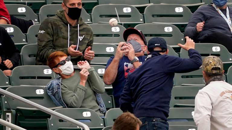 Fans try to catch a foul ball hit by Colorado Rockies' Charlie Blackmon during the first inning of a spring training baseball game, Saturday, March 13, 2021, in Scottsdale, Ariz. (Matt York/AP)