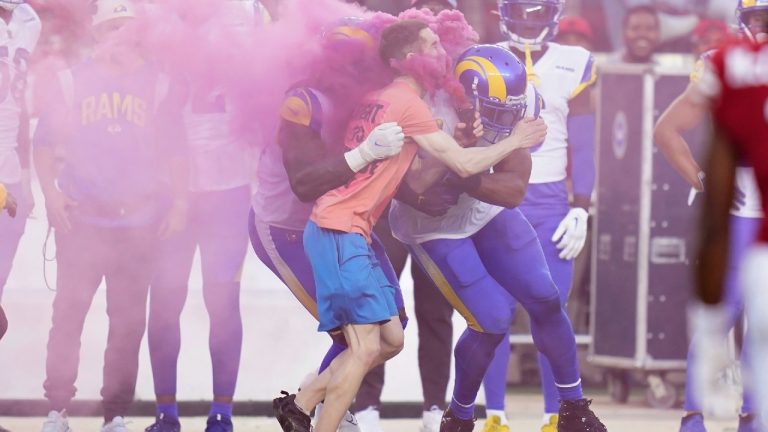 A protester is hit by Los Angeles Rams defensive end Takkarist McKinley, middle left, and linebacker Bobby Wagner during the first half of an NFL football game between the San Francisco 49ers and the Rams in Santa Clara, Calif., Monday, Oct. 3, 2022. (Godofredo A. Vasquez/AP)