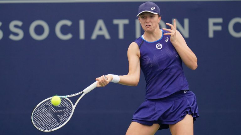 Iga Swiatek of Poland returns to Qinwen Zheng of China as they warm up before a rain delay at the San Diego Open tennis tournament Thursday, Oct. 13, 2022, in San Diego. (Gregory Bull/AP)