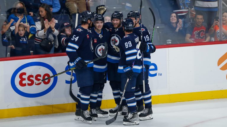 Winnipeg Jets' Dylan Samberg (54), Ville Heinola (14), Dominic Toninato (21), Sam Gagner (89) and David Gustafsson (19) celebrate a goal against the Calgary Flames during second period NHL pre-season game action in Winnipeg on Wednesday, October 5, 2022. (John Woods/CP)