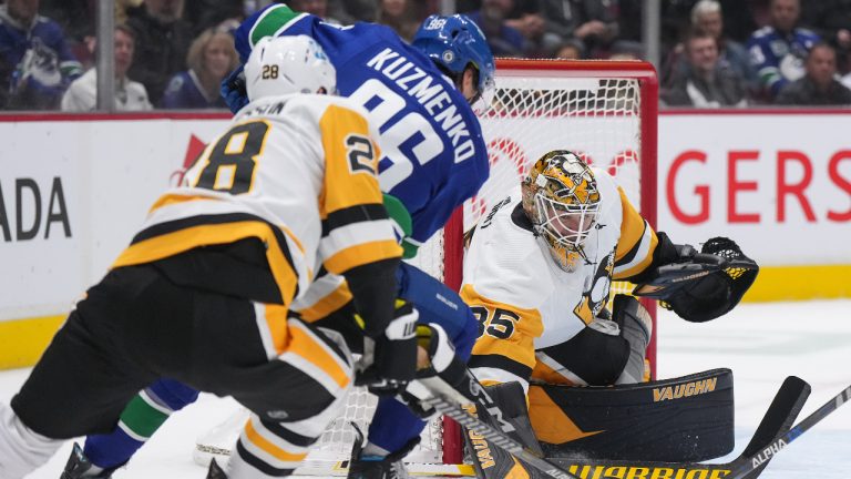 Pittsburgh Penguins goalie Tristan Jarry (35) stops Vancouver Canucks' Andrei Kuzmenko (96), of Russia, as Pittsburgh's Marcus Pettersson (28), of Sweden, defends during the first period of an NHL hockey game in Vancouver, on Friday, October 28, 2022. (Darryl Dyck/CP)