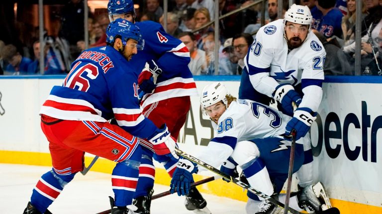 New York Rangers center Vincent Trocheck (16) and Tampa Bay Lightning left wing Nicholas Paul (20) reach for the puck during the first period of an NHL hockey game Tuesday, Oct. 11, 2022, in New York. (Julia Nikhinson/AP Photo)