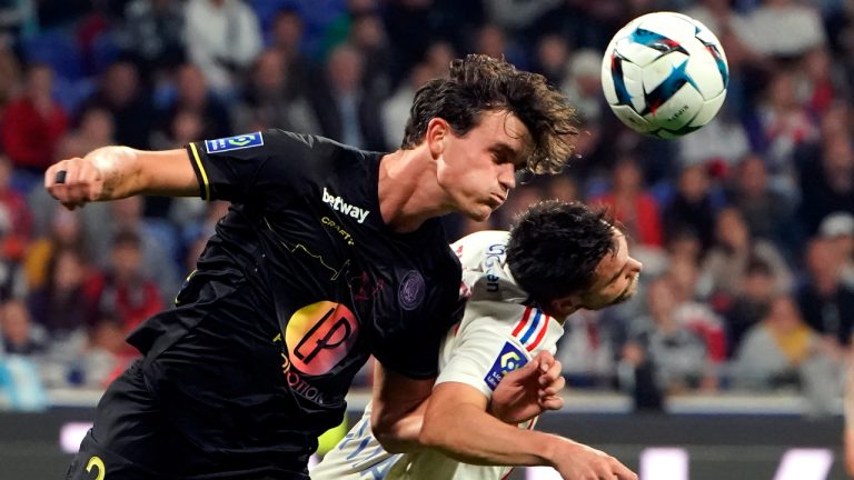 Lyon's Nicolas Tagliafico, right, challenges for the ball with Toulouse's Rasmus Nicolaisen during the French League One soccer match between Lyon and Toulouse in Decines, near Lyon, central France, Friday, Oct. 7, 2022. (Laurent Cipriani/AP)