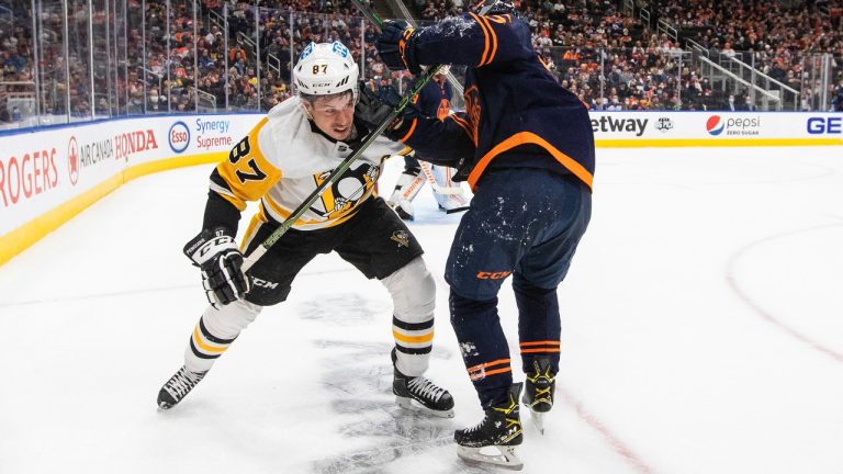 Pittsburgh Penguins' Sidney Crosby (87) and Edmonton Oilers' Evan Bouchard (75) battle for the puck during third period NHL action in Edmonton on Wednesday, December 1, 2021. (Jason Franson/CP)