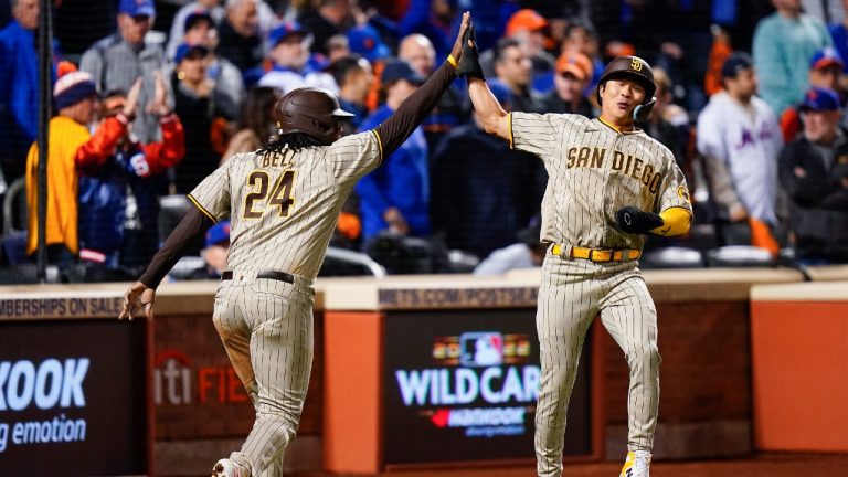 San Diego Padres Josh Bell (24) celebrates with Ha-Seong Kim after scoring against the New York Mets on a base hit by Austin Nola during the second inning of Game 3 of a National League wild-card baseball playoff series, Sunday, Oct. 9, 2022, in New York. (Frank Franklin II/AP)