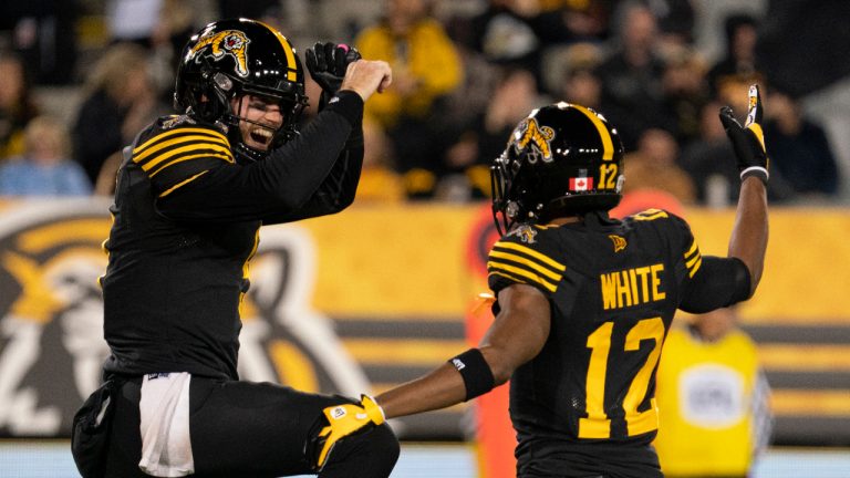 Hamilton Tiger-Cats quarterback Dane Evans (9) celebrates his touchdown with Tim White (12) during first half CFL football game action against the Saskatchewan Roughriders in Hamilton, on Friday, October 7, 2022. (Peter Power/CP)
