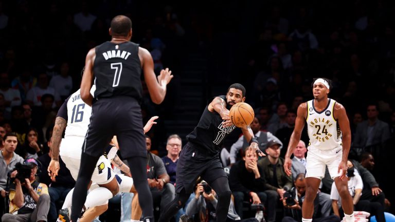 Brooklyn Nets guard Kyrie Irving (11) passes the ball to forward Kevin Durant (7) as Indiana Pacers guard Buddy Hield (24) watches during the first half of an NBA basketball game. (Jessie Alcheh/AP)