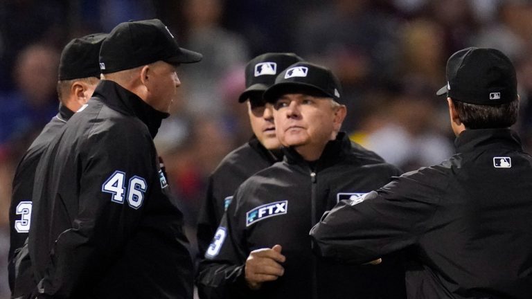 Umpires confer about the ruling on a double hit by Tampa Bay Rays center fielder Kevin Kiermaier during the thirteenth inning against the Boston Red Sox during Game 3 of a baseball American League Division Series, Sunday, Oct. 10, 2021, in Boston. 