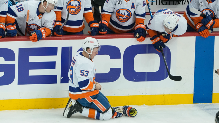 New York Islanders' Casey Cizikas (53) kneels on the ice in front of his bench after he was hit by a stick during the first period of an NHL hockey game against the Pittsburgh Penguins, Thursday, April 14, 2022, in Pittsburgh. Penguins' Mark Friedman was penalized 4 minutes for high-sticking on the play. (AP Photo/Keith Srakocic)