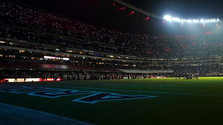 Players for the Arizona Cardinals and the San Francisco 49ers wait on the field during a lighting display in the second half of an NFL football game Monday, Nov. 21, 2022, in Mexico City. (Fernando Llano/AP)