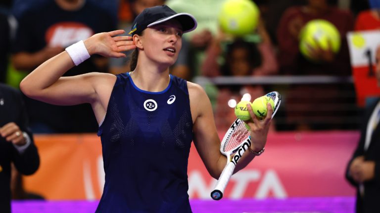 Iga Swiatek of Poland listens for cheers before hitting autographed balls into the stands after defeating Daria Kasatkina of Russia during round robin play on day two of the WTA Finals tennis tournament in Fort Worth, Texas, Monday, Oct. 31, 2022. Swiatek won 6-2, 6-3. (Ron Jenkins/AP)