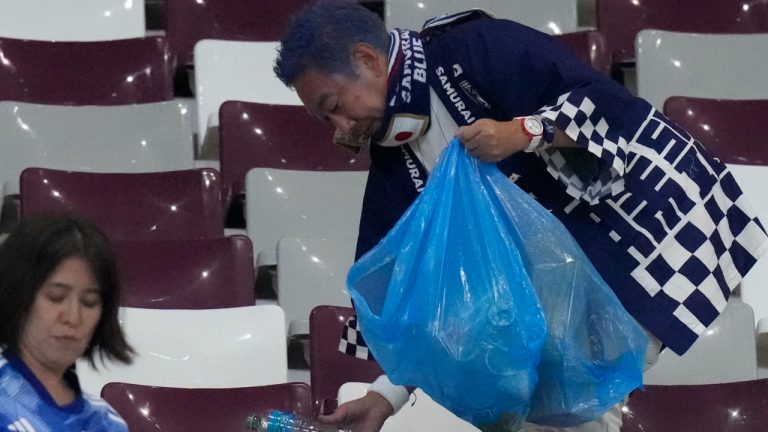 Japan supporters clean the stands at the end of the World Cup group E soccer match between Germany and Japan, at the Khalifa International Stadium in Doha, Qatar, Wednesday, Nov. 23, 2022. Japan won 2-1.(Eugene Hoshiko/AP)