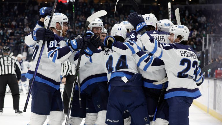 Winnipeg Jets players surround defenceman Josh Morrissey (44) while celebrating his winning goal against the Seattle Kraken during overtime period of an NHL hockey game, Sunday, Nov. 13, 2022, in Seattle. (John Froschauer/AP)