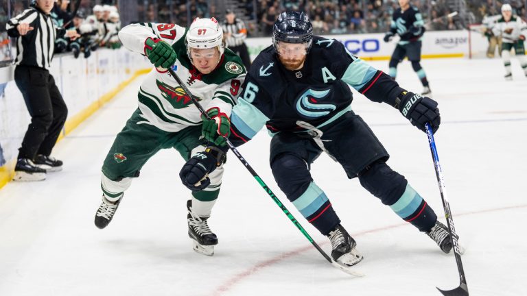Minnesota Wild forward Kirill Kaprizov, left, and Seattle Kraken defenceman Adam Larsson chase down the puck during the first period of an NHL hockey game, Friday, Nov. 11, 2022, in Seattle. (Stephen Brashear/AP)