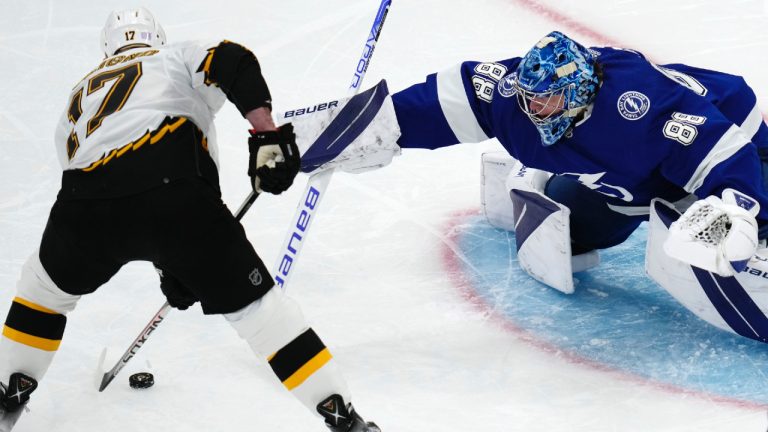 Tampa Bay Lightning goaltender Andrei Vasilevskiy (88) tries to knock the puck away from Boston Bruins left wing Nick Foligno (17) during the third period of an NHL hockey game Tuesday, Nov. 29, 2022, in Boston. (Charles Krupa/AP)